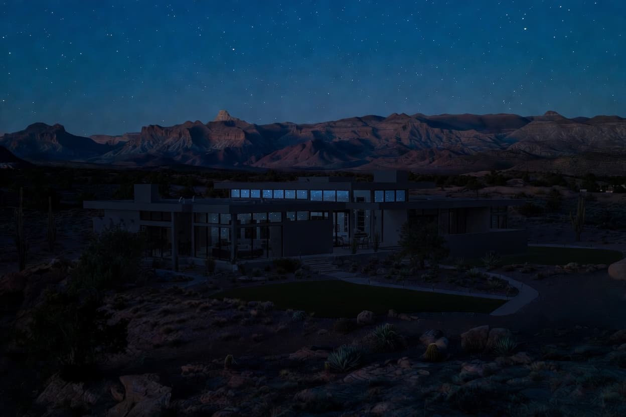 Custom home at night with the lights off, set against the desert landscape