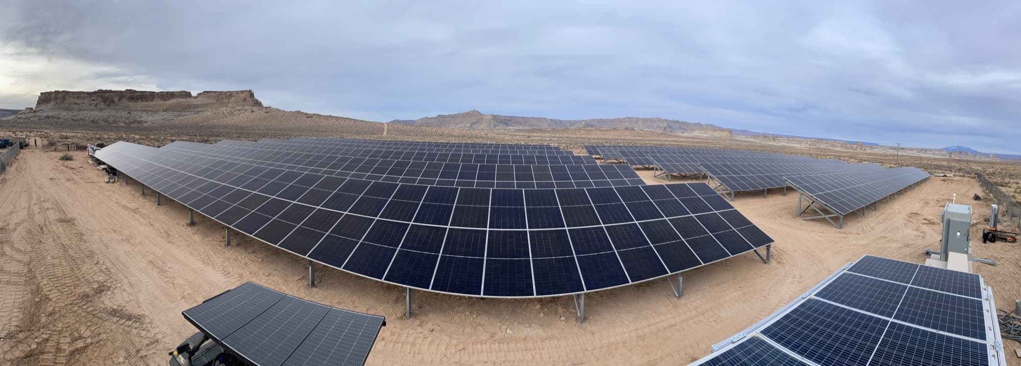 Panoramic view of a large commercial ground-mount solar array in the desert